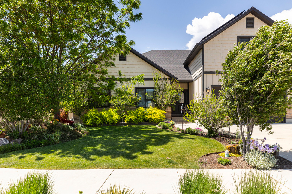View of front facade featuring a front lawn and roof with shingles