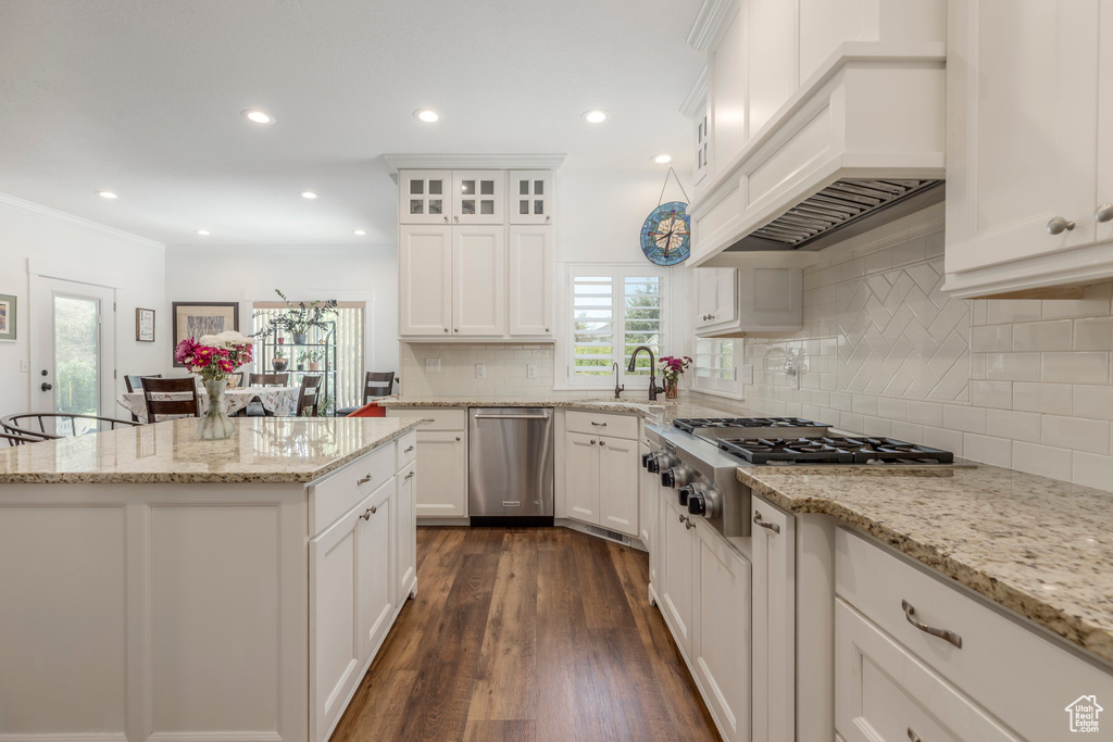 Kitchen with stainless steel appliances, healthy amount of natural light, tasteful backsplash, white cabinetry, and recessed lighting