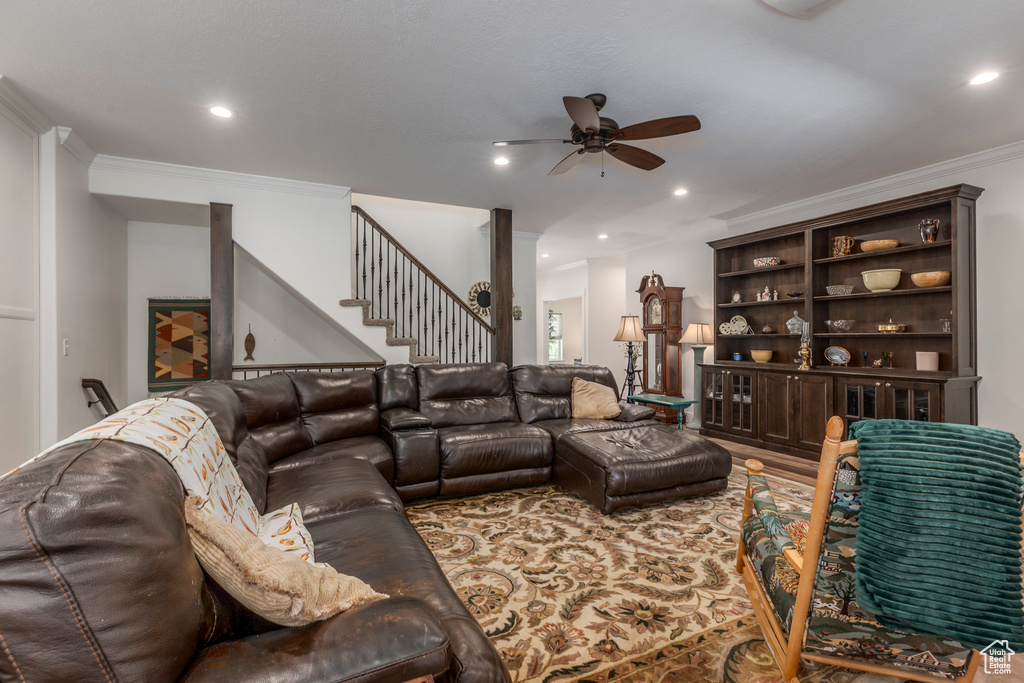 Living room with ceiling fan, crown molding, stairway, recessed lighting, and ornate columns