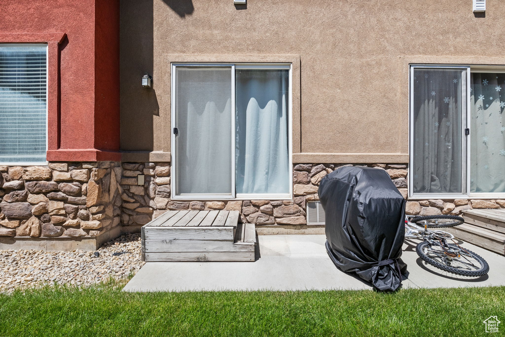 Entrance to property featuring stone siding and stucco siding