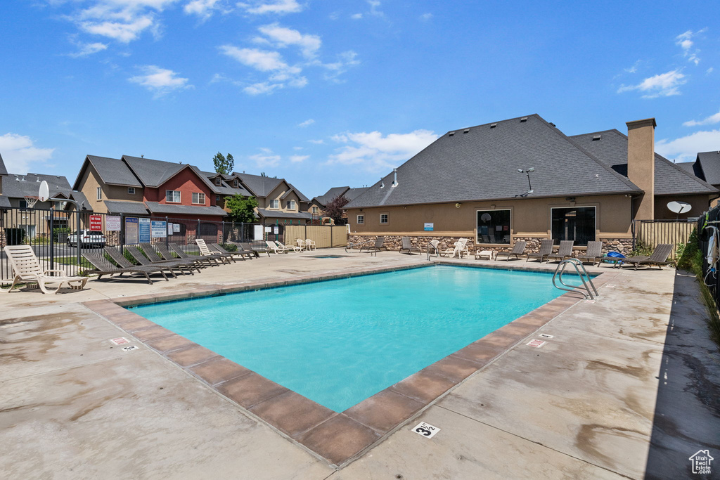 Community pool with a patio area and a residential view