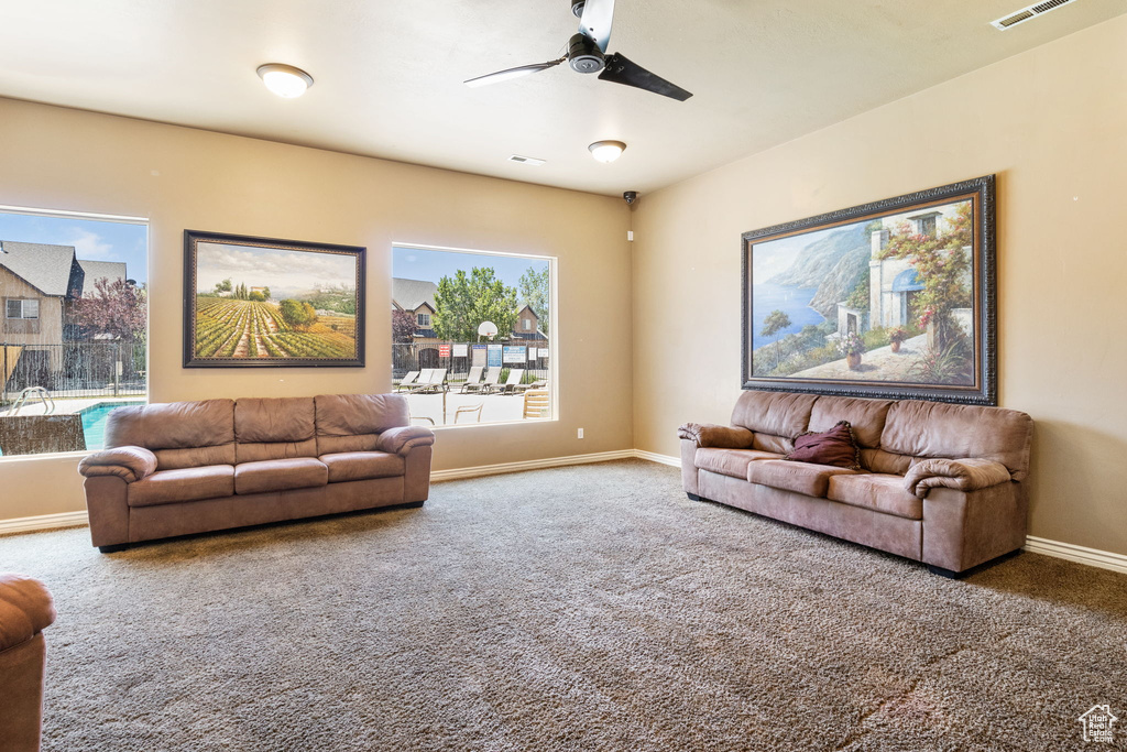 Living area featuring carpet flooring and ceiling fan