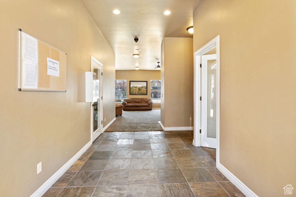 Hallway featuring stone tile floors, french doors, and recessed lighting