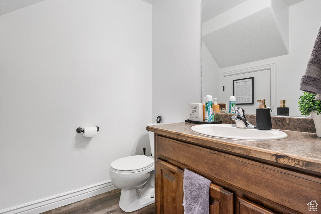 Half bathroom featuring vanity and wood finished floors