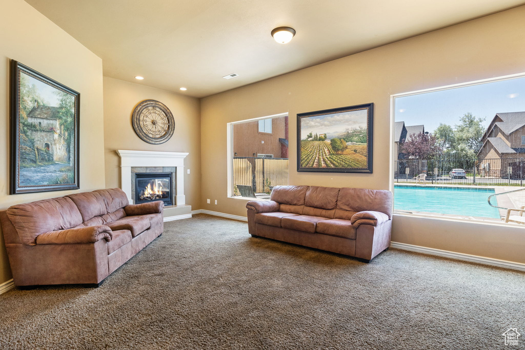 Carpeted living room featuring plenty of natural light, a fireplace, and recessed lighting