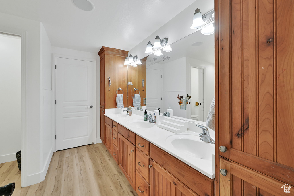 Full bathroom with wood finished floors and double vanity