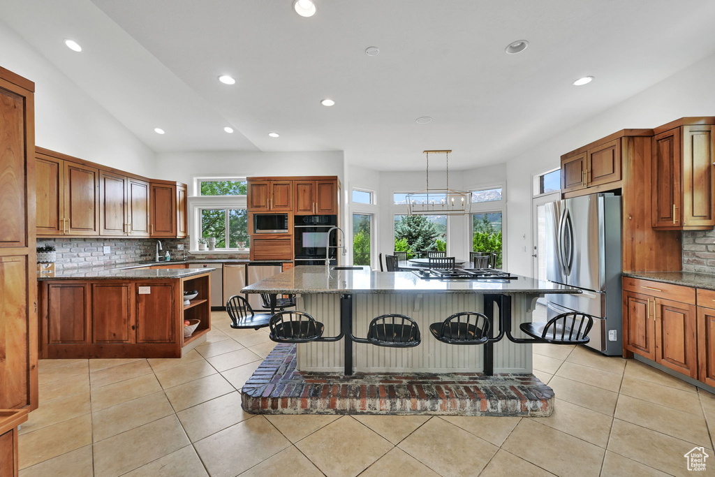 Kitchen featuring black appliances, a kitchen bar, backsplash, recessed lighting, and open shelves