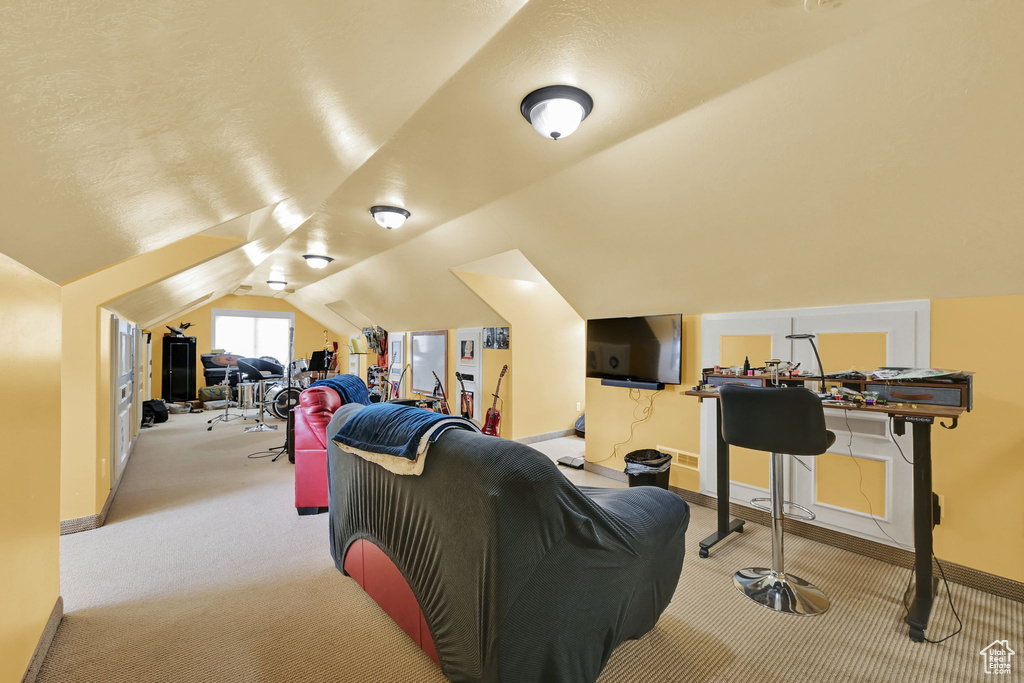 Home theater featuring carpet and vaulted ceiling