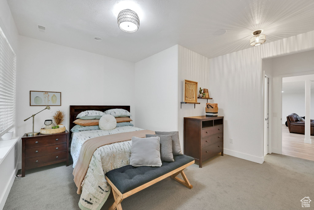 Bedroom featuring light colored carpet and baseboards