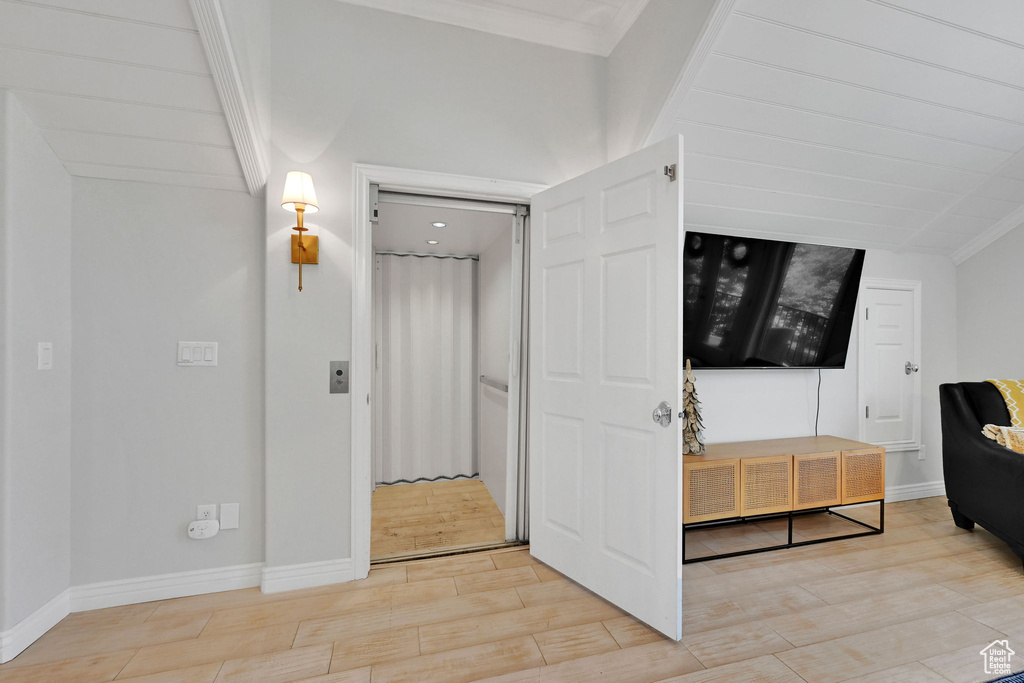 Entrance foyer with light wood-style flooring and crown molding