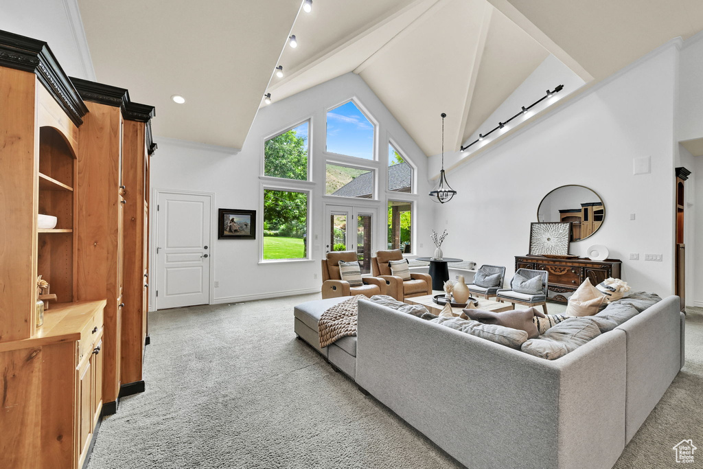 Living area with light carpet and high vaulted ceiling