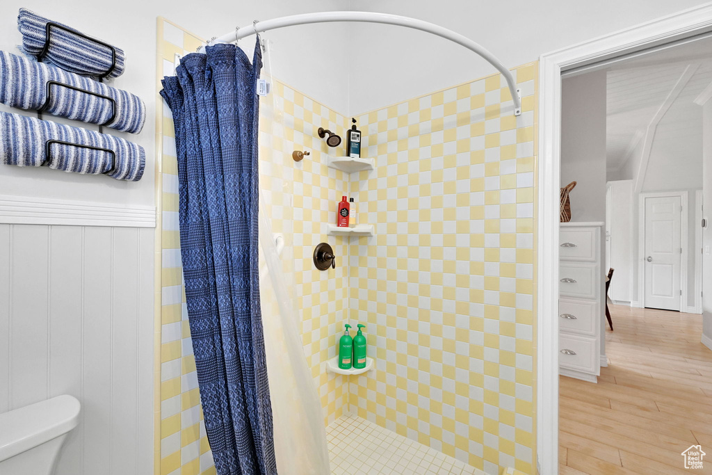 Full bathroom featuring a stall shower and wood finished floors