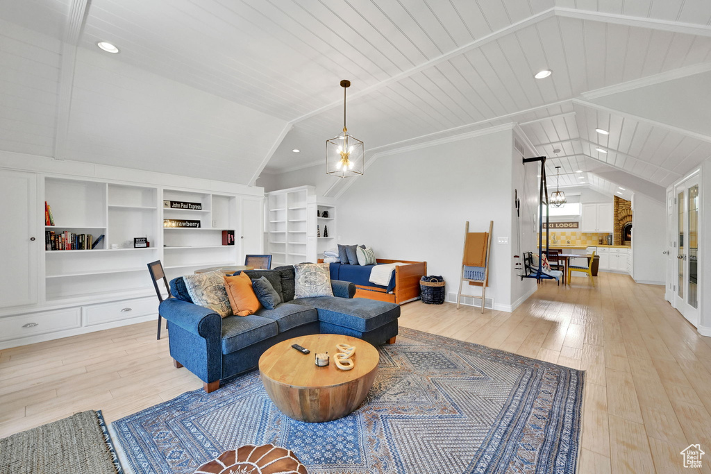 Living room with lofted ceiling, light wood-type flooring, built in shelves, wooden ceiling, and recessed lighting