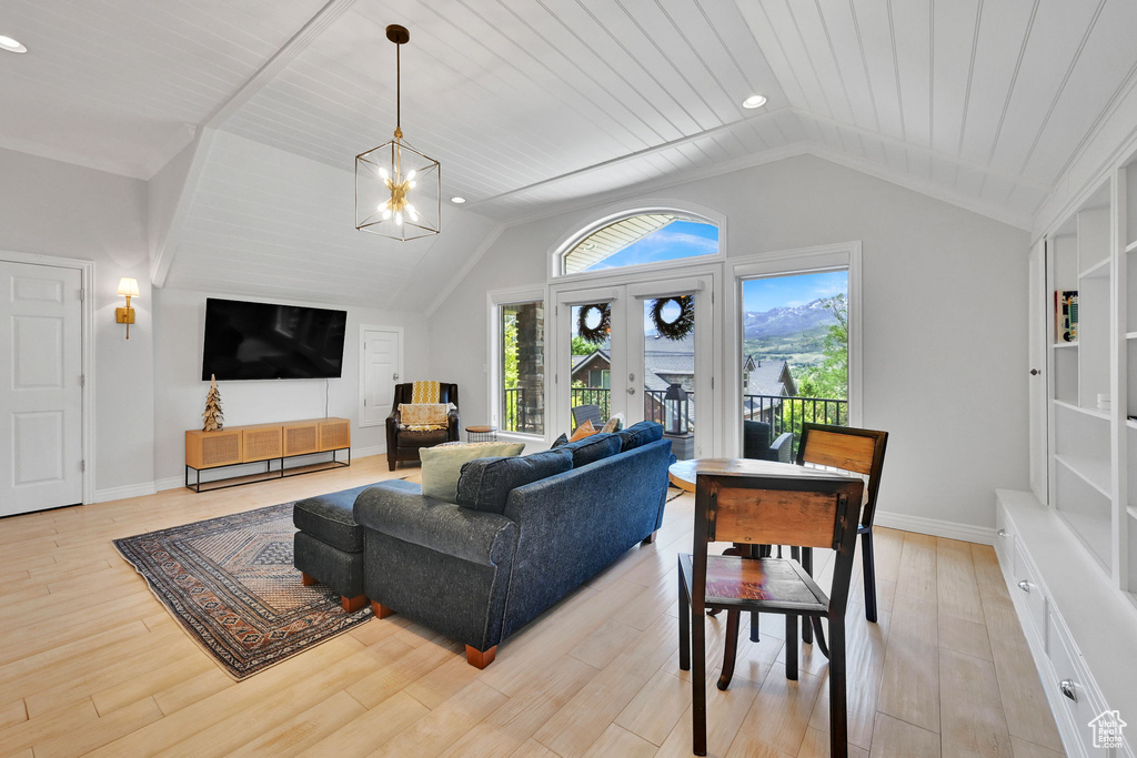 Living area featuring lofted ceiling, light wood finished floors, a chandelier, and recessed lighting