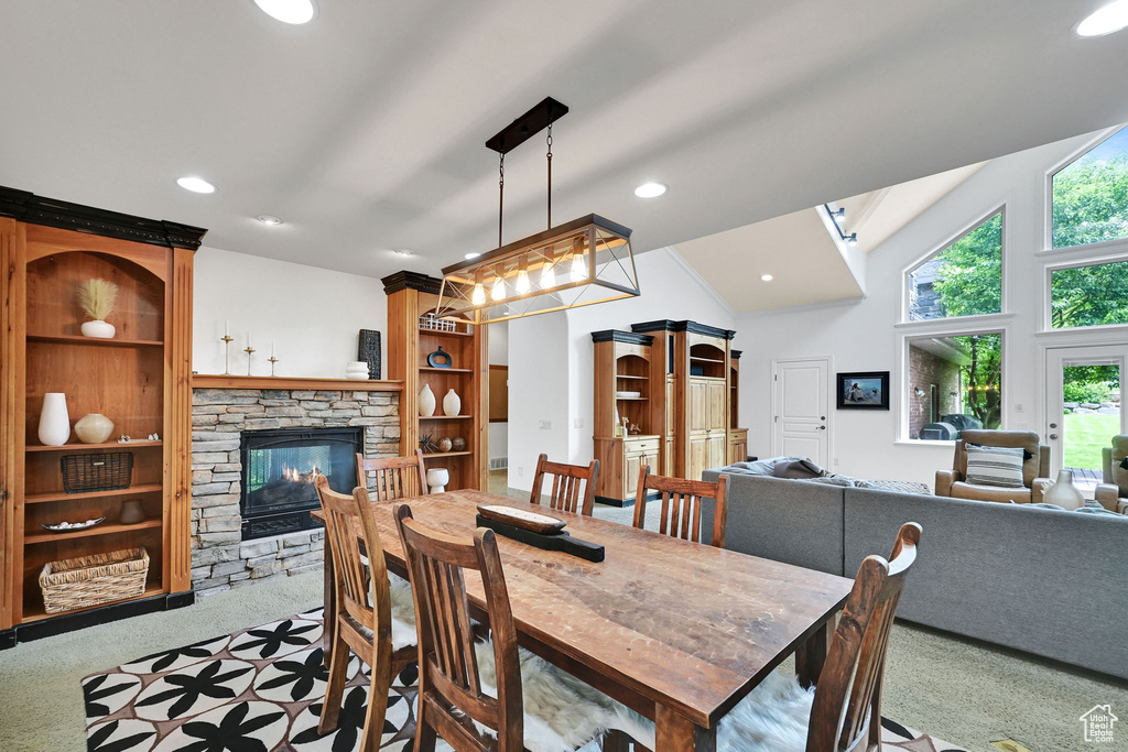 Dining space with healthy amount of natural light, carpet flooring, a fireplace, recessed lighting, and lofted ceiling