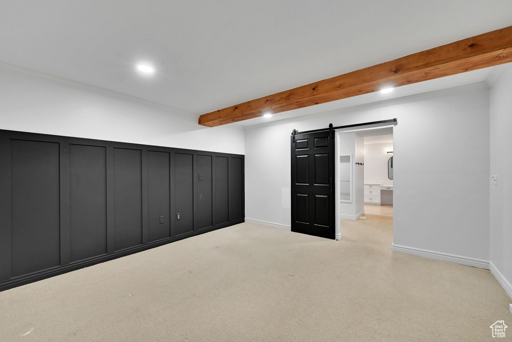 Below grade area with a barn door, recessed lighting, and carpet floors