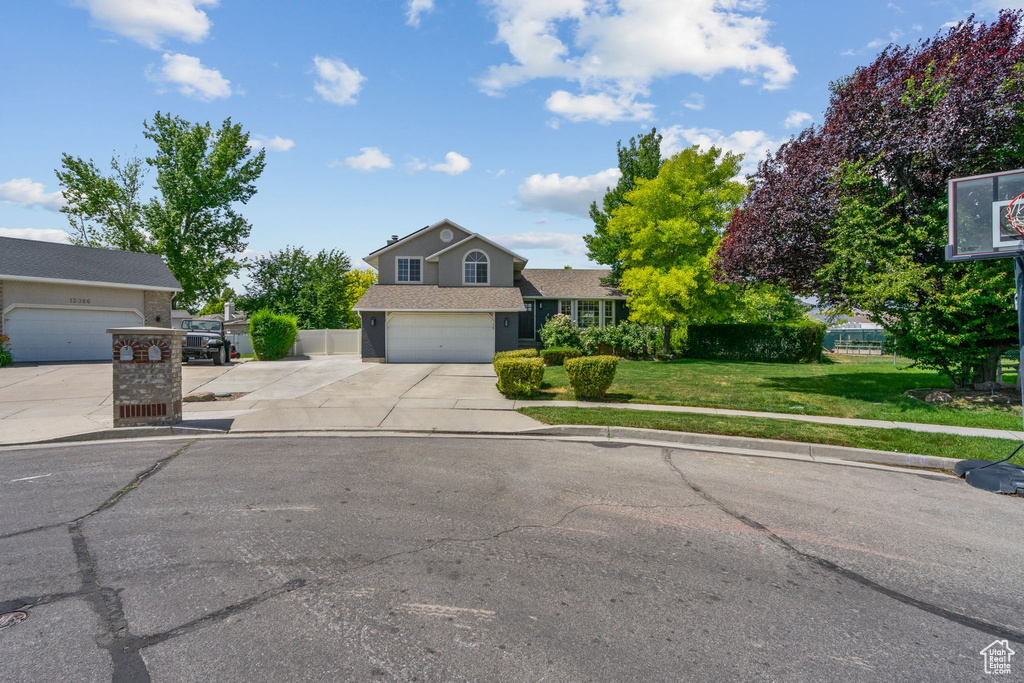 View of front facade featuring concrete driveway and an attached garage