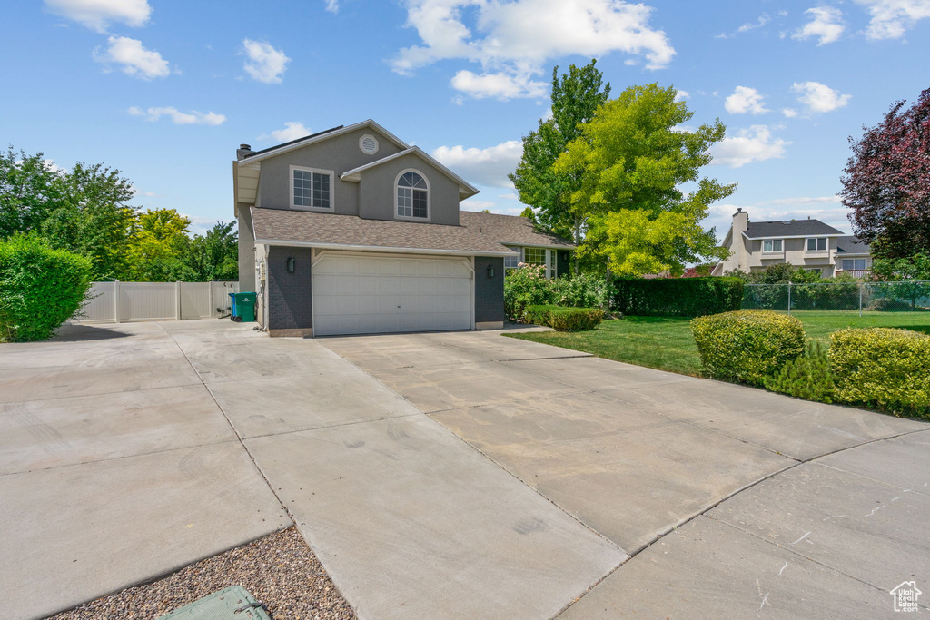 Traditional-style home with concrete driveway, an attached garage, and stucco siding