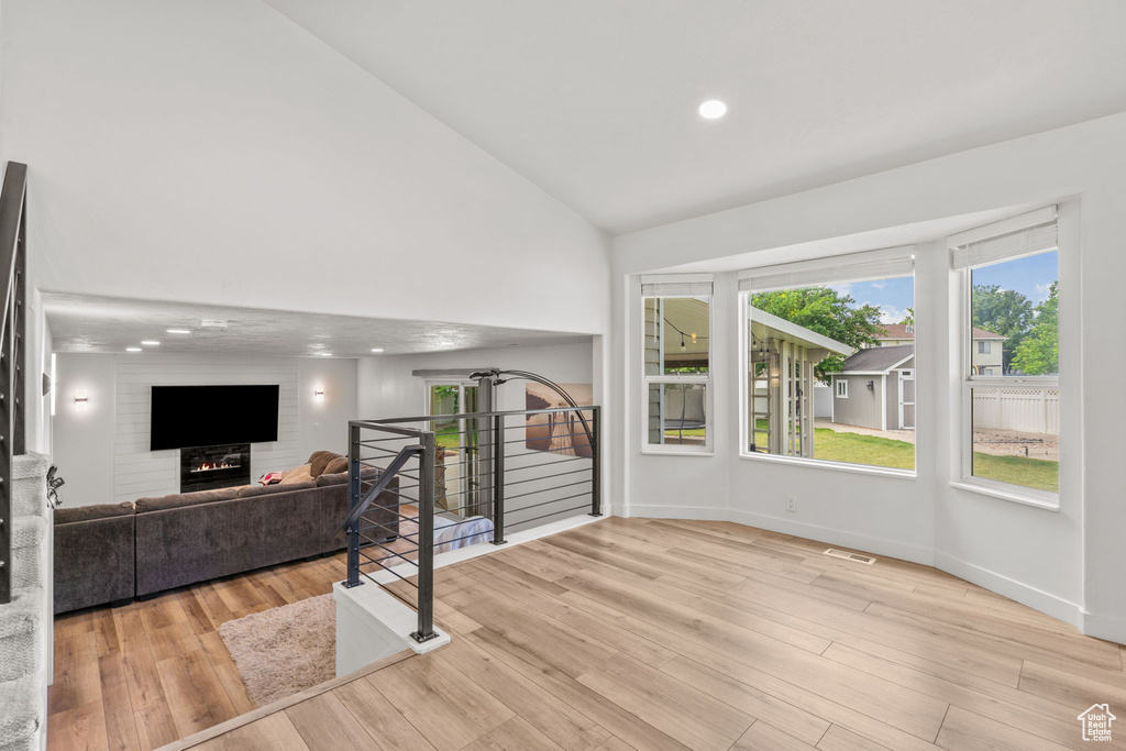 Living area featuring high vaulted ceiling, wood finished floors, and recessed lighting