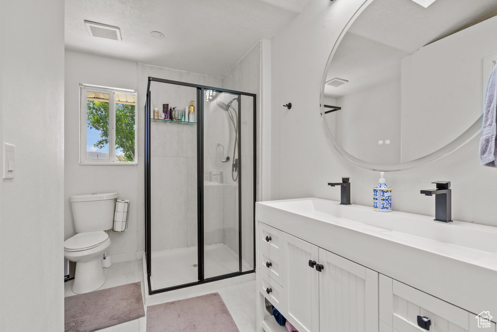 Full bathroom with vanity, a stall shower, and tile patterned flooring