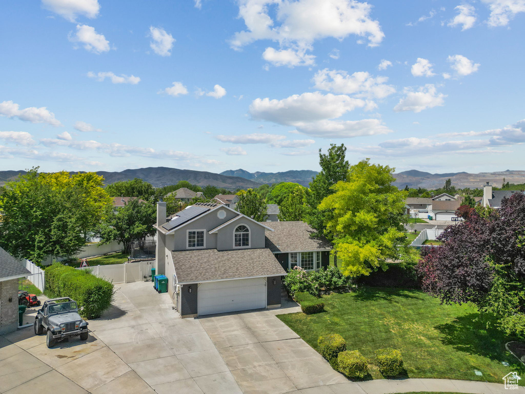 View of front of property featuring a chimney, a mountain view, a garage, driveway, and stucco siding