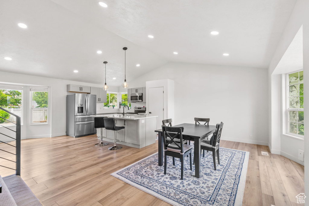 Dining space featuring lofted ceiling, light wood-style flooring, and recessed lighting