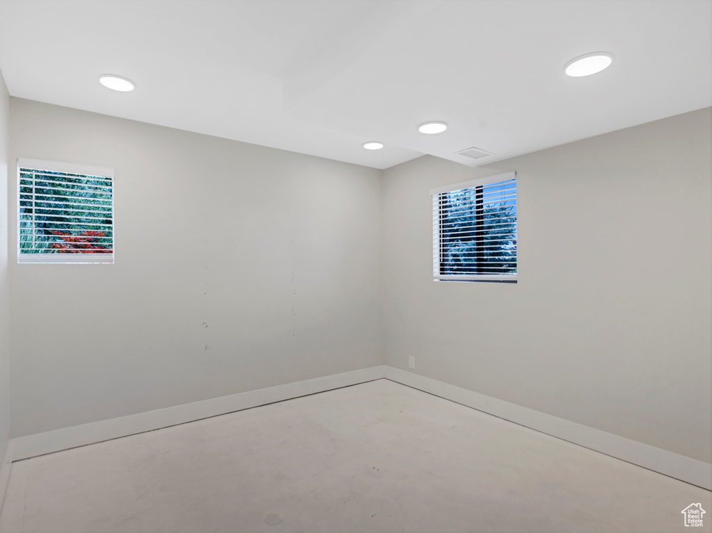 Spare room featuring plenty of natural light, concrete flooring, and recessed lighting