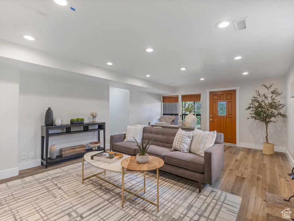 Living area with light wood-type flooring and recessed lighting