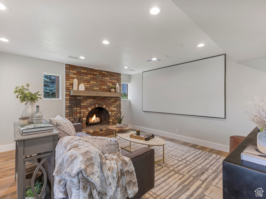Cinema featuring light wood-style flooring, a fireplace, and recessed lighting