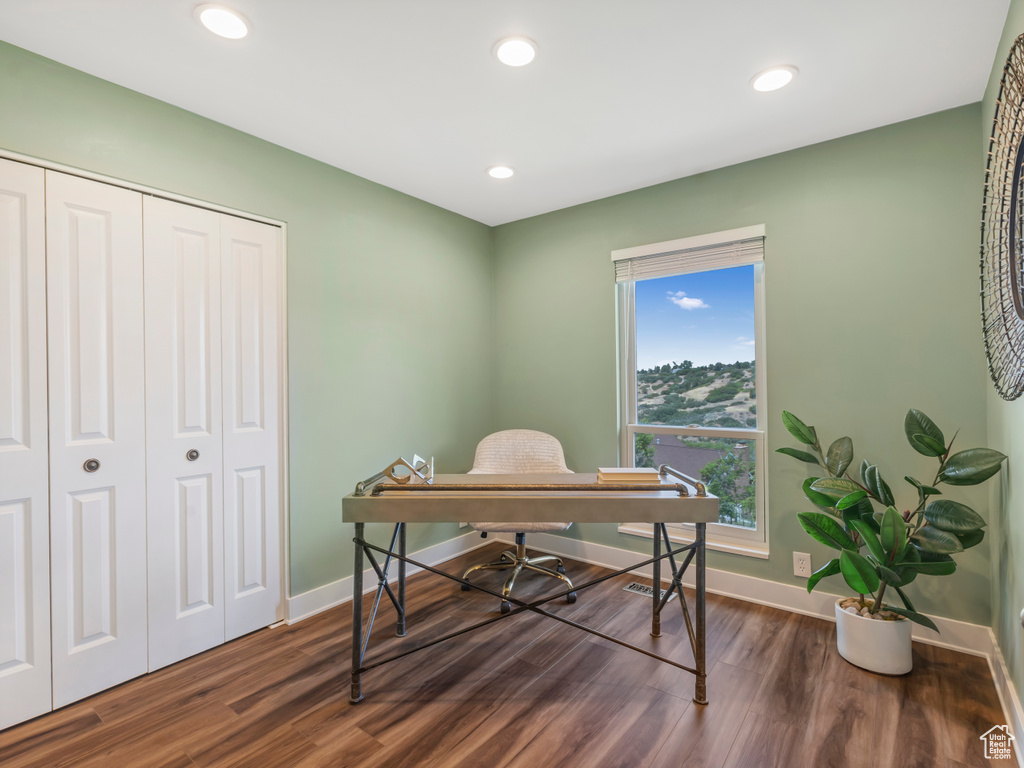 Home office with dark wood finished floors and recessed lighting