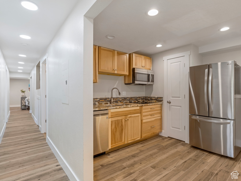 Kitchen featuring appliances with stainless steel finishes, light wood-style floors, light stone countertops, recessed lighting, and light brown cabinetry