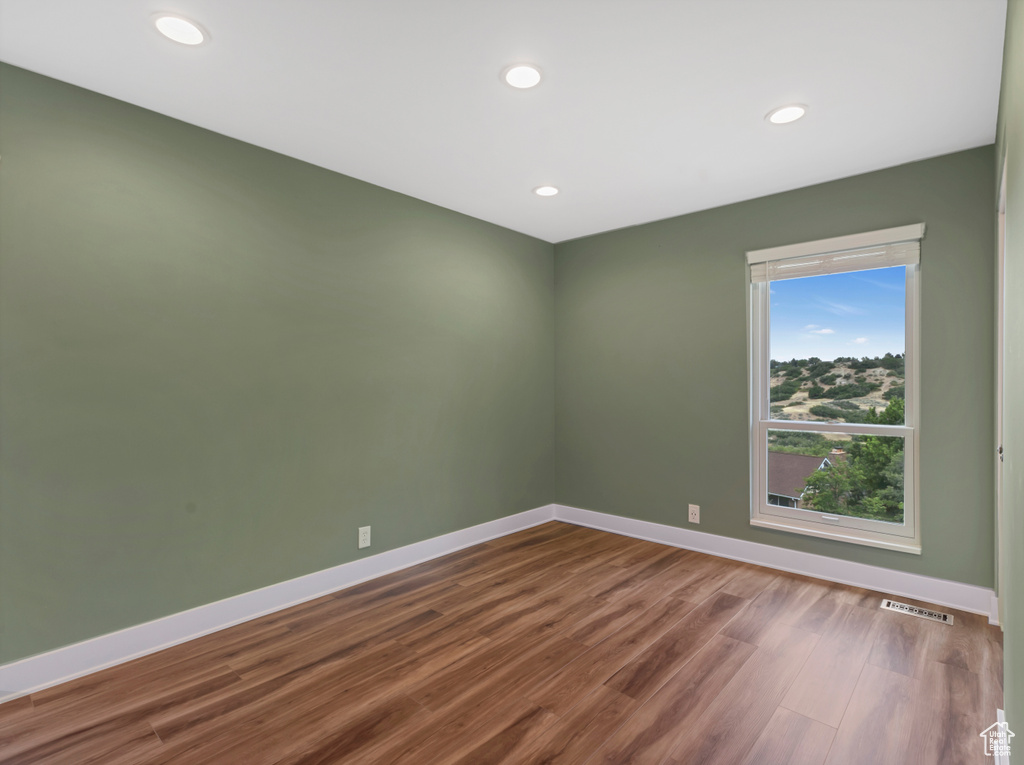 Empty room featuring dark wood-style flooring and recessed lighting