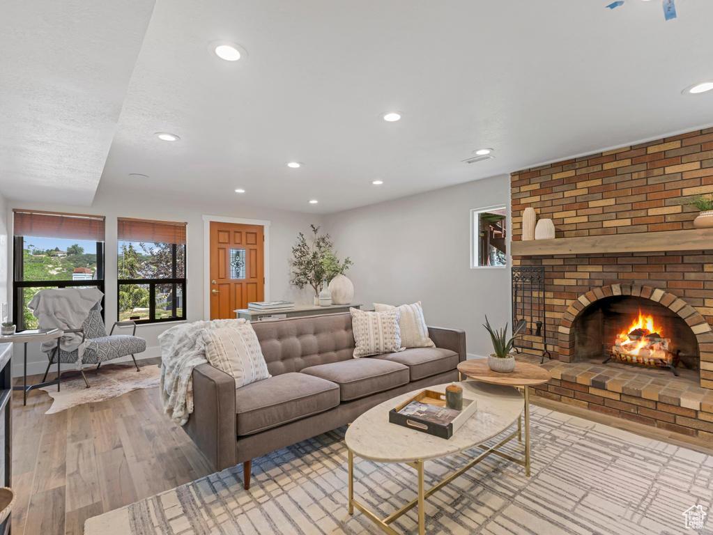 Living area featuring recessed lighting, wood finished floors, and a fireplace