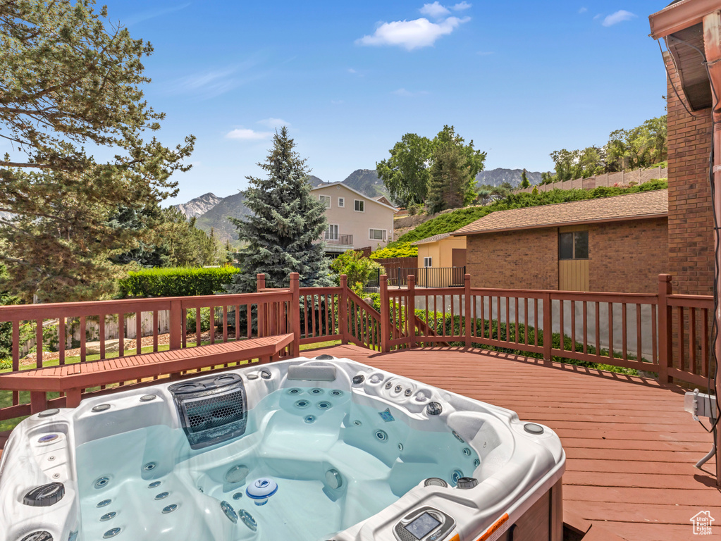 Wooden deck with an outdoor hot tub and a mountain view