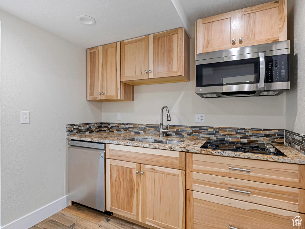Kitchen featuring appliances with stainless steel finishes, light brown cabinetry, and light wood finished floors