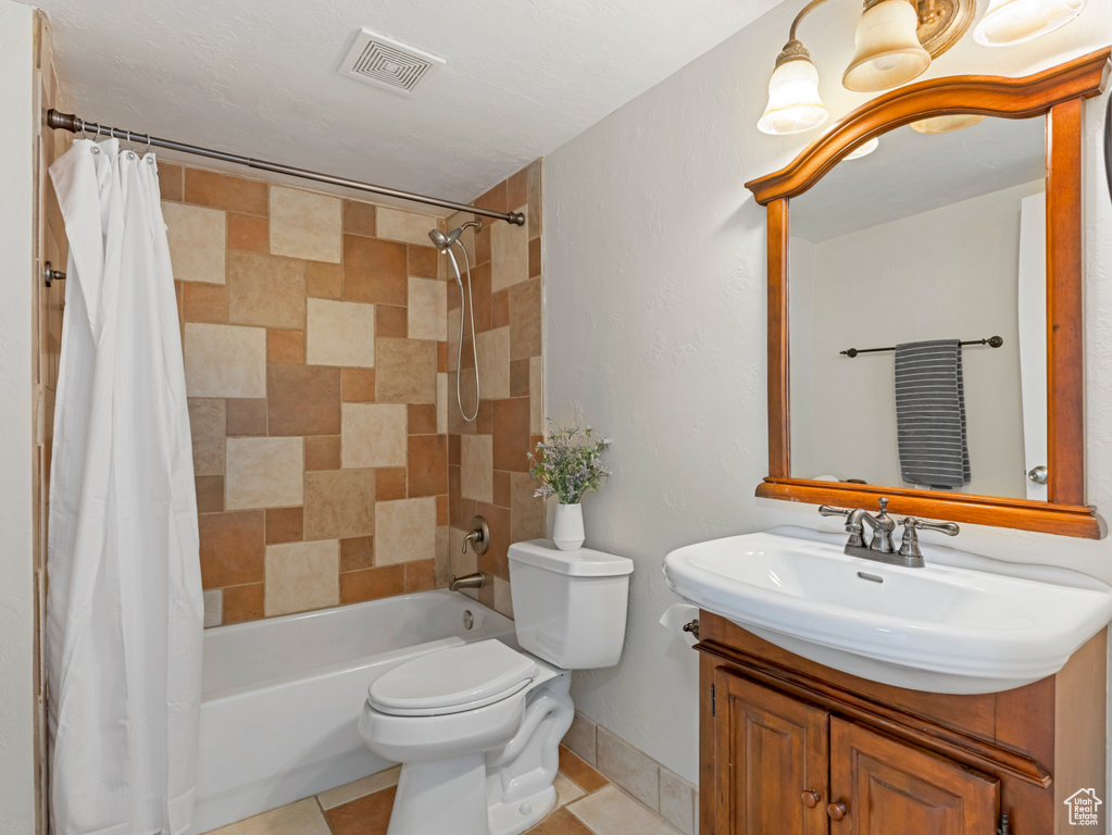 Full bathroom with vanity, shower / bathtub combination with curtain, and tile patterned floors