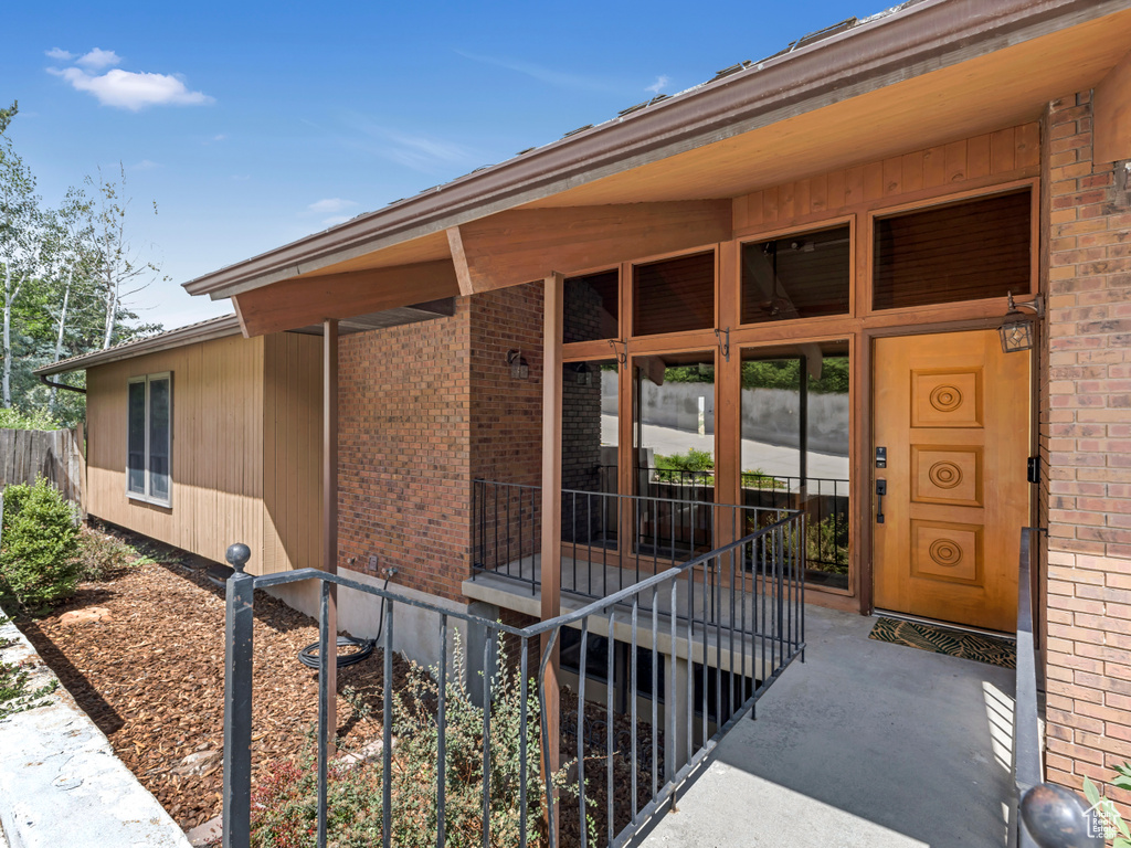 Property entrance with brick siding and a porch