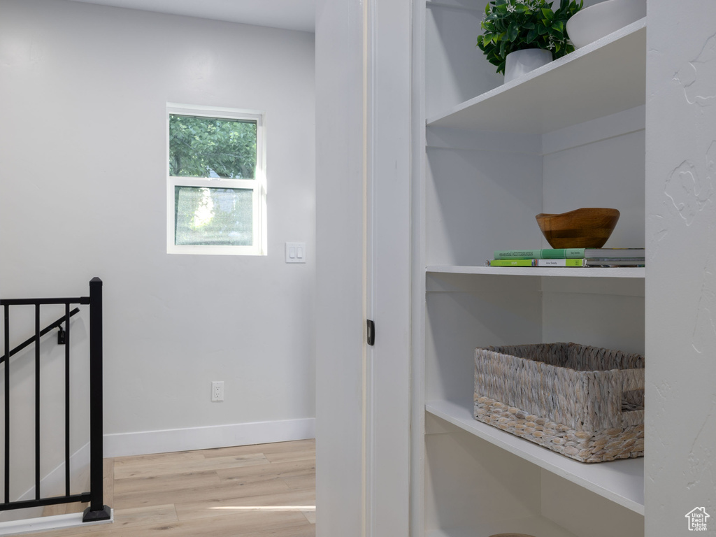 Hallway with wood finished floors and baseboards