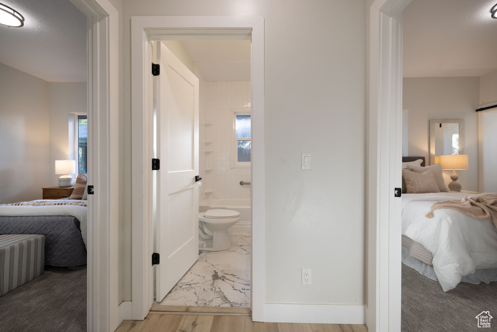 Ensuite bathroom featuring marble finish flooring and shower / washtub combination