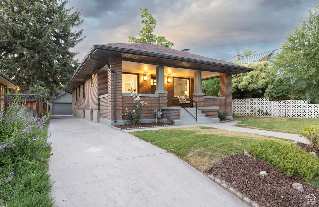 View of front of house featuring brick siding, an outdoor structure, and a detached garage