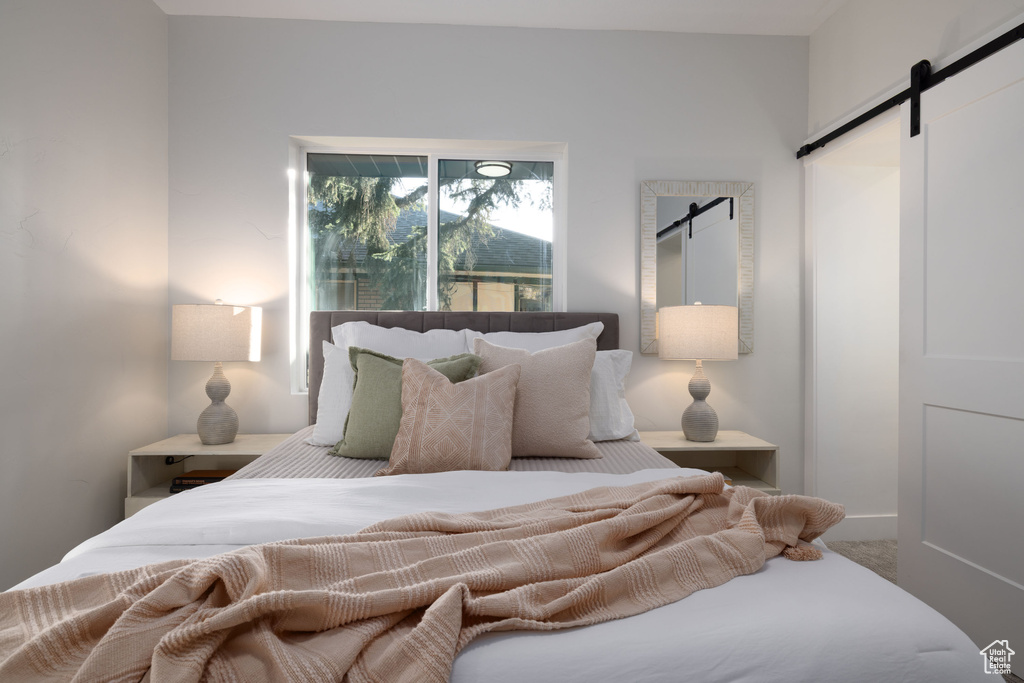 Bedroom featuring a barn door and carpet
