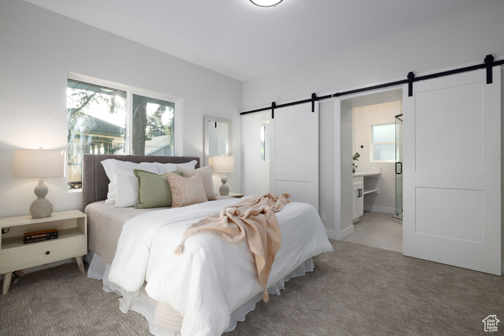 Bedroom with a barn door and light carpet