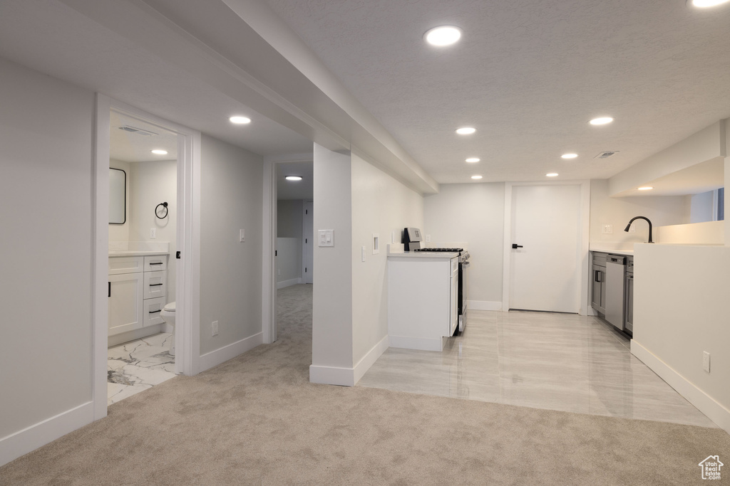 Below grade area featuring recessed lighting and light colored carpet