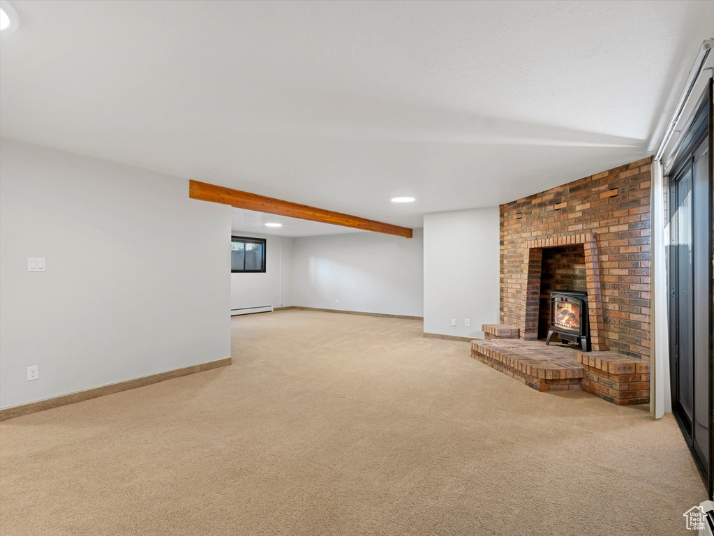 Unfurnished living room featuring a wood stove, light colored carpet, baseboard heating, beamed ceiling, and recessed lighting