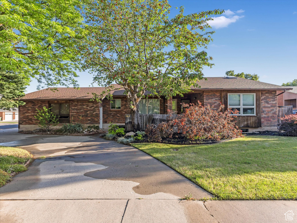 Ranch-style house featuring brick siding and a front yard