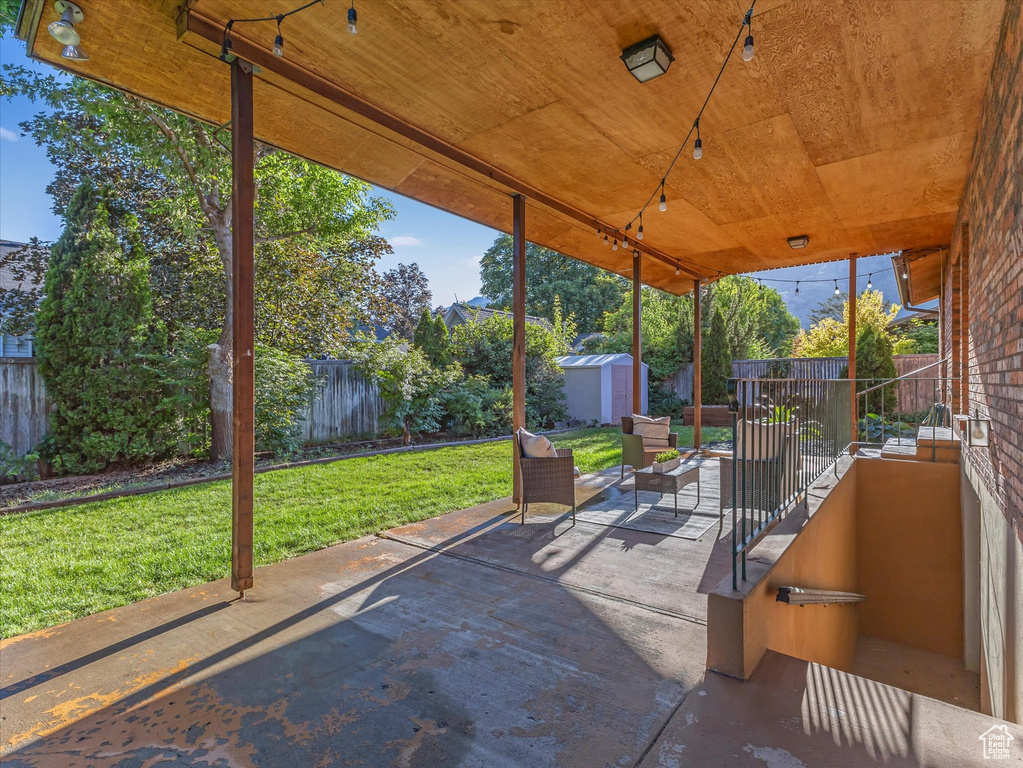 Fenced backyard with a storage unit and a patio area