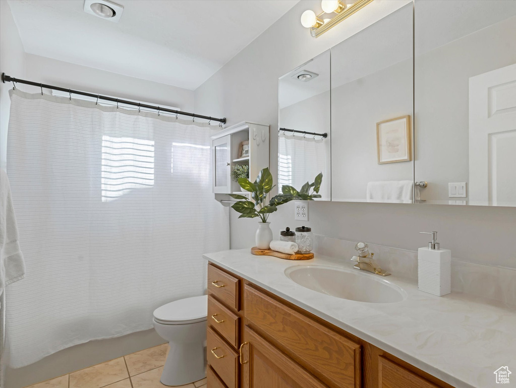 Bathroom with tile patterned flooring, vanity, and curtained shower