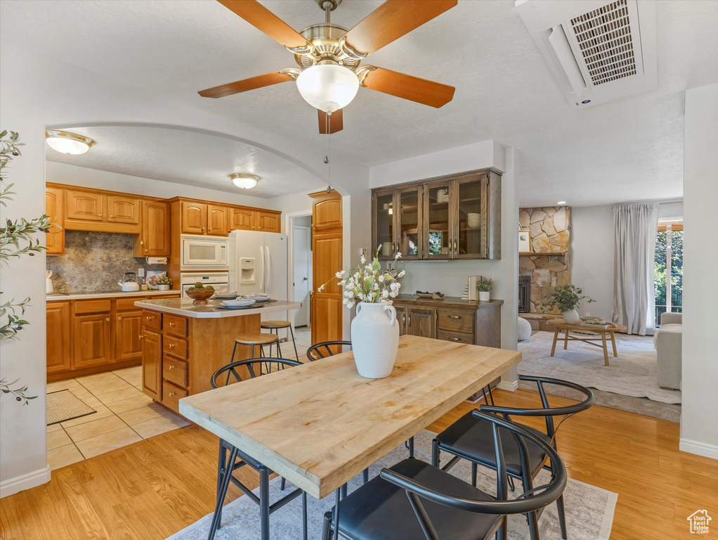 Dining space with a ceiling fan and light wood-style floors