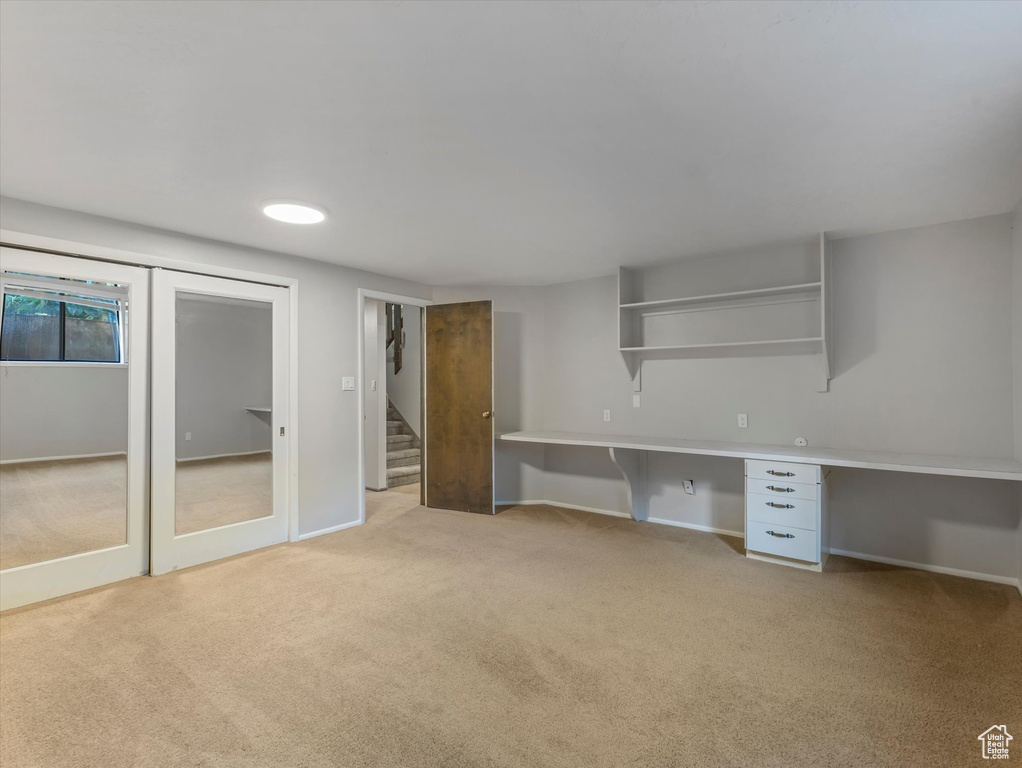 Unfurnished office with light colored carpet and built in desk