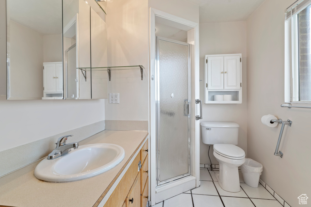 Full bath featuring vanity, a stall shower, and tile patterned flooring